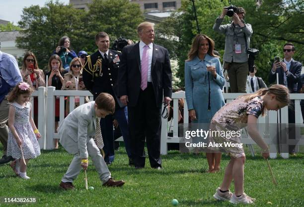 President Donald Trump and first lady Melania Trump watch children participating in the 141st Easter Egg Roll on the South Lawn of the White House...