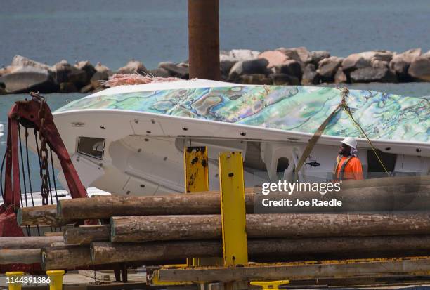 Barge is used to carry a 32-foot center console boat that crashed over the weekend into Government Cut’s north jetty killing three people on April...