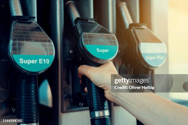 one person uses a fuel pump - gas prices stock-fotos und bilder