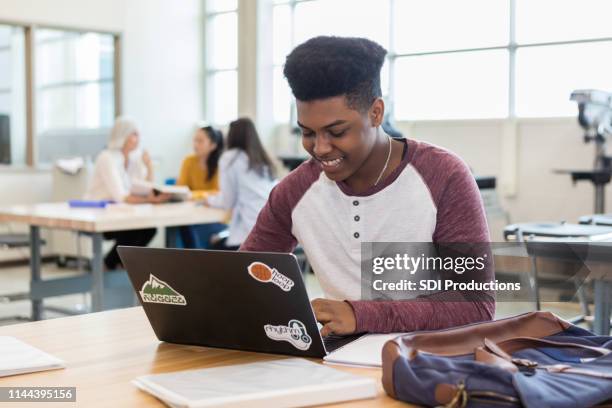 ein afroamerikanischer teenager surft das netz nach ideen - sekundarschule stock-fotos und bilder