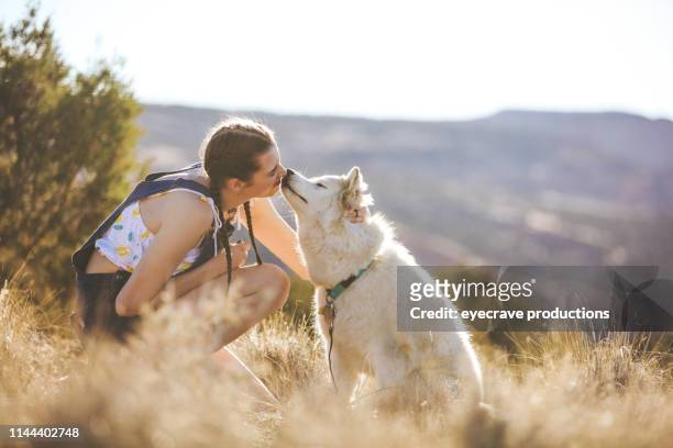 energieke tiener vrouw exploring colorado buitenshuis met husky hond in de wilde serie - desert dog stockfoto's en -beelden
