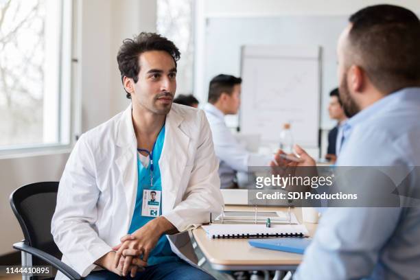 een arts van het midden-oosten etniciteit luistert naar verkoper - arabic doctor stockfoto's en -beelden