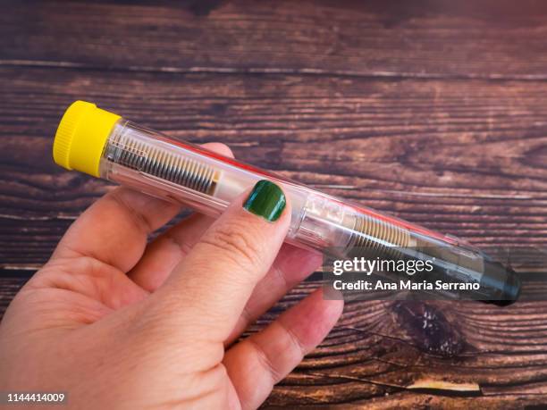 one person with an adrenalin injection pen - adrenaline injection stock pictures, royalty-free photos & images