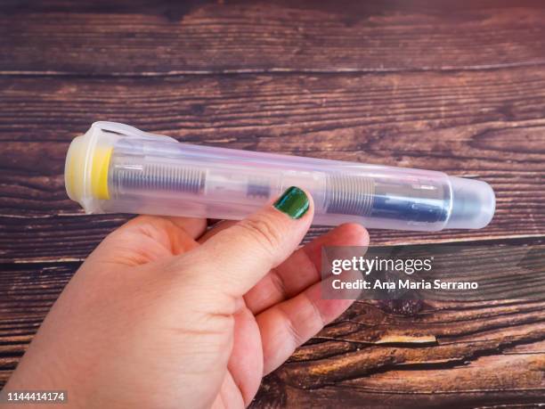 one person with an adrenalin injection pen - epipen stock pictures, royalty-free photos & images