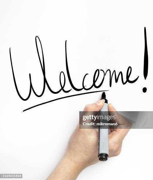 hand writing welcome on white page with marker - welcome sign stock pictures, royalty-free photos & images