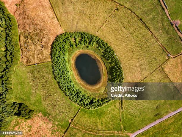 drone landscape view with lines and textures in the background. aerial view of beautiful lagoon in the azores islands. op view of volcanic crater, tourist attraction of portugal. - volcanic crater stock-fotos und bilder