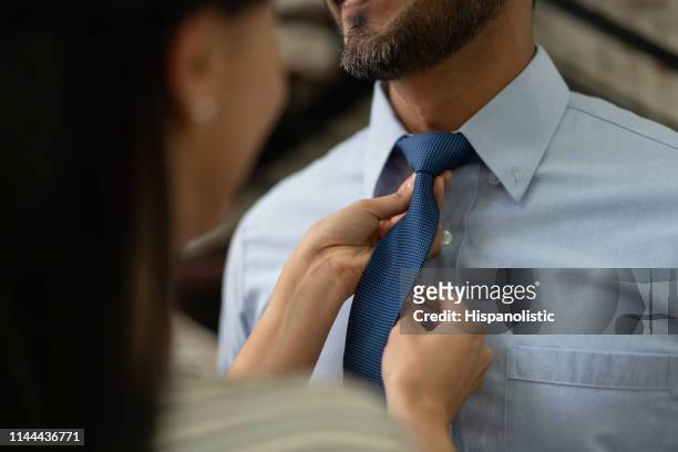 nahaufnahme der liebevollen frau hilft partner mit seiner krawatte - krawatte stock-fotos und bilder