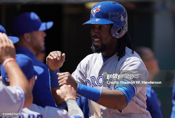 Alen Hanson of the Toronto Blue Jays is congratulated by teammates after he scored against the Oakland Athletics in the top of the third inning of a...