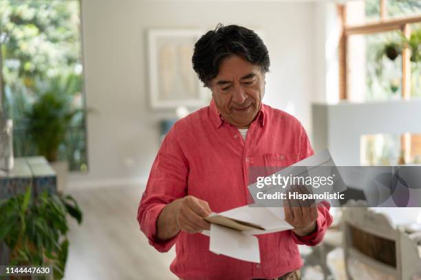 cheerful senior man at home looking at his mail - reading mail stock pictures, royalty-free photos & images
