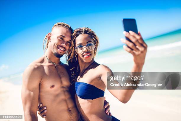 afro-amerikanisches paar nimmt selfie am strand - afro caribbean and american stock-fotos und bilder