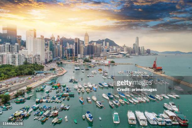 vue aérienne panoramique du paysage urbain de la ligne d’horizon de la ville de hong kong et du port de victoria au coucher du soleil - victoria harbour hong kong photos et images de collection