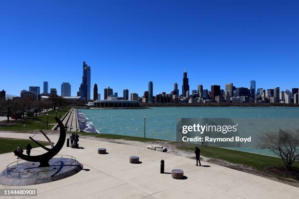 Chicago Skyline with Henry Moore's 'Man Enters The Cosmos' sundial sculpture outside Adler Planetarium in Chicago, Illinois on April 20, 2019....