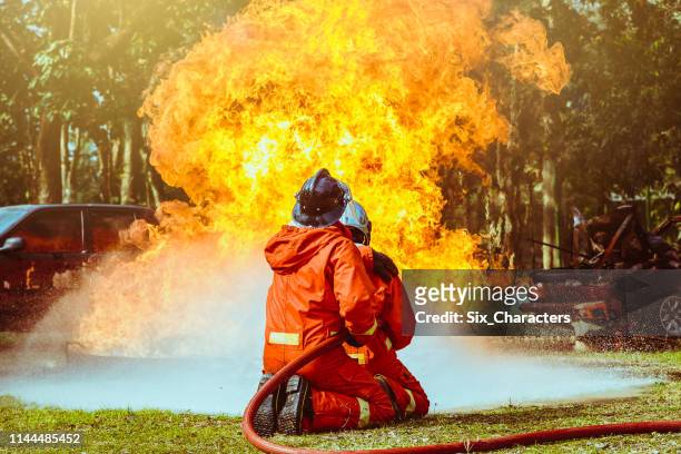 bomberos que luchan contra una operación de incendio, agua pulverizada por una boquilla de alta presión para fuego envolvente con humo, bomberos extinguir una casa - carro de bombeiro fotografías e imágenes de stock