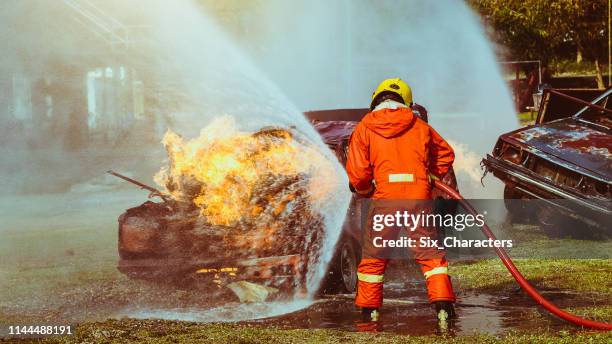 bomberos que luchan contra una operación de incendio, agua pulverizada por una boquilla de alta presión para fuego envolvente con humo, bomberos extinguir una casa - carro de bombeiro fotografías e imágenes de stock