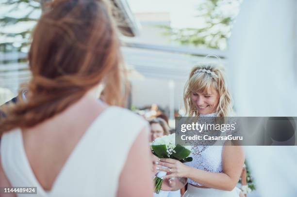 smiling bride holding bouquet - civil partnership stock pictures, royalty-free photos & images