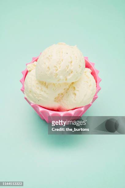 close-up of scoop of vanilla ice cream in a pink bowl - ice cream scoop stock-fotos und bilder