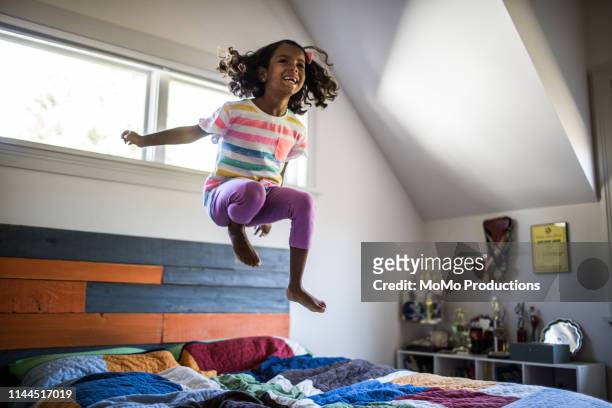 girl jumping on bed - children jumping bed stock pictures, royalty-free photos & images