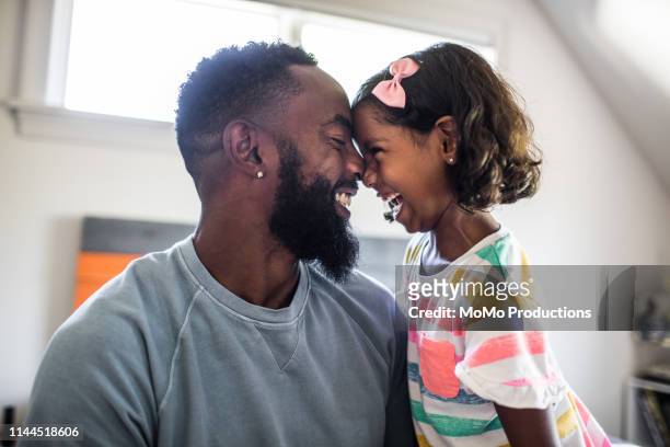 father and daughter laughing in bedroom - ethnische zugehörigkeit stock-fotos und bilder