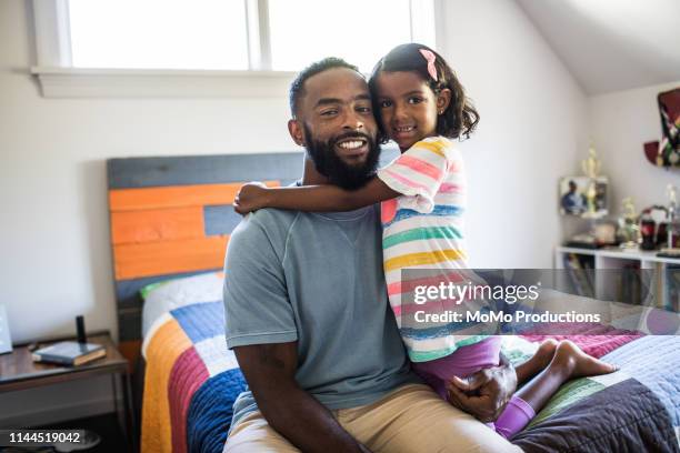 father and daughter laughing in bedroom