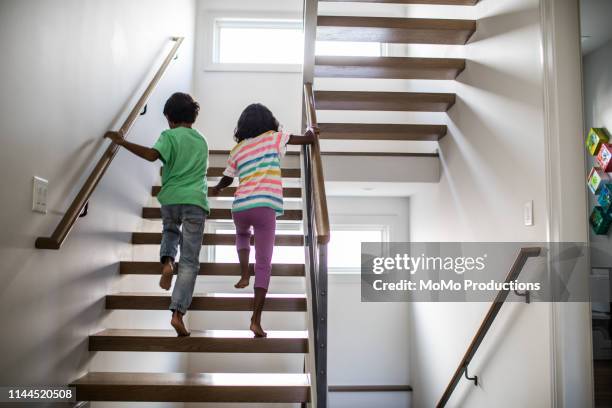 children running up staircase at home - step sibling stock pictures, royalty-free photos & images