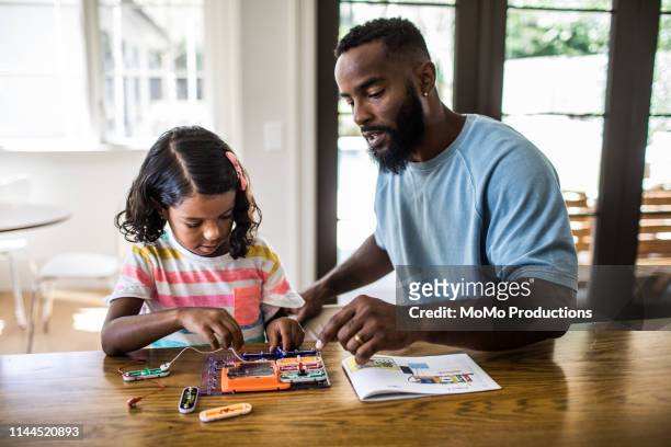 father and daughter working on science project at home - homework table stock pictures, royalty-free photos & images