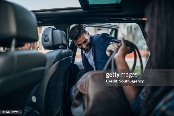mann geht in eine fahrt mit dem auto - taxi fahrgemeinschaft stock-fotos und bilder