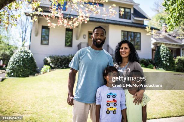 portrait of family in front of home - family of four in front of house stock-fotos und bilder