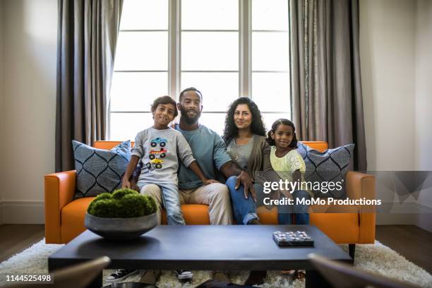 portrait of family in living room - mixed race person stockfoto's en -beelden