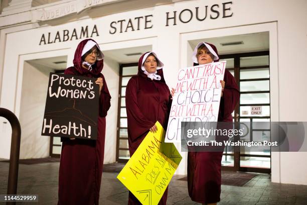 Women wearing Handmaid costumes protest in front of the Alabama State House after the State Senate passed HB314, which banned abortions in all cases...