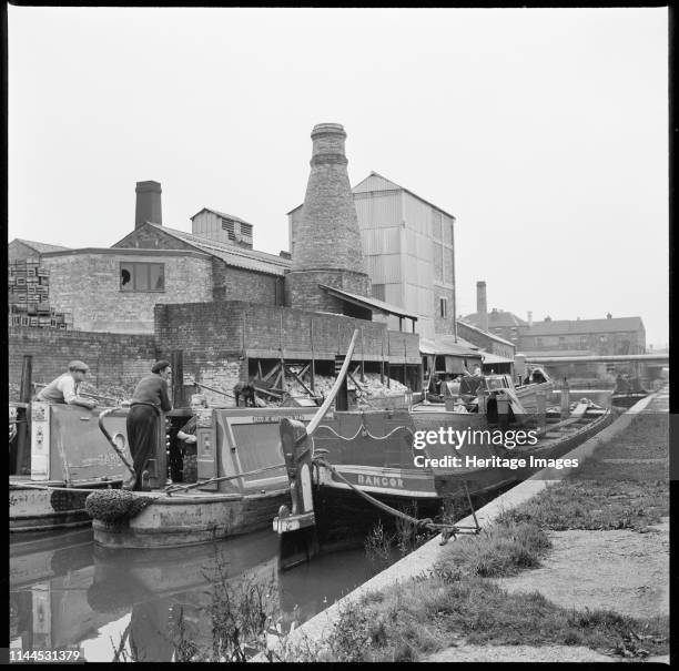 Barges on the Trent & Mersey Canal, Stoke-on-Trent, 1965-1968. A group of barges beside W J Dolby's flint calcinating kiln. Artist Eileen Deste.