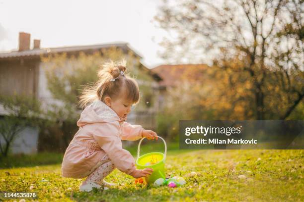 spielen auf dem rasen neben dem haus während der ostern - easter egg hunt stock-fotos und bilder