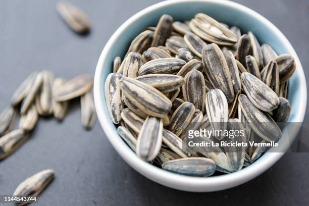 bowl of sunflower seeds - sonnenblumenkerne stock-fotos und bilder