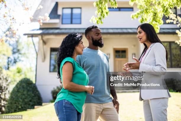 couple meeting with real estate agent in front of home - finanzen und wirtschaft stock-fotos und bilder