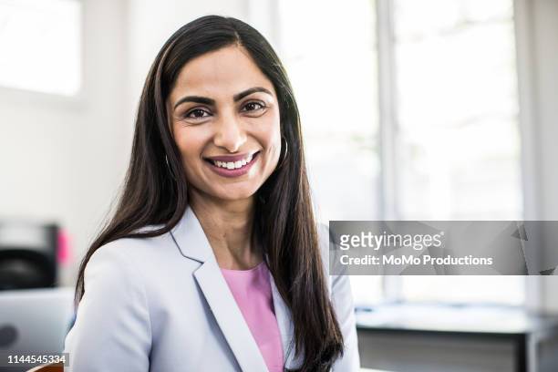 woman in business office - asian and indian ethnicities stock-fotos und bilder