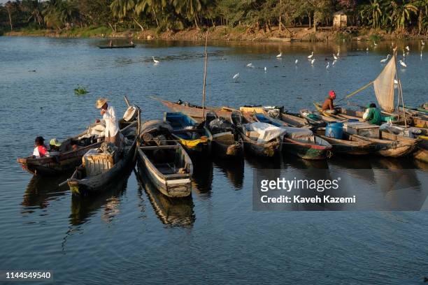 Fishermen relax and tidy up their nets after a morning of fishing on the Magdalena River on February 5, 2019 in Barranquilla, Colombia.