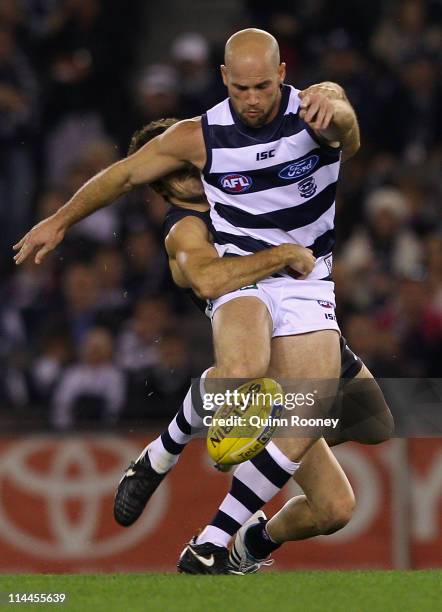 Paul Chapman of the Cats kicks whilst being tackled by Kade Simpson of the Blues during the round nine AFL match between the Carlton Blues and the...