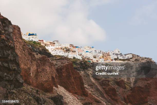 village and red volcanic rocks, oia, santorini, greece - firak stock pictures, royalty-free photos & images