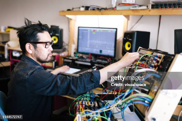 homme asiatique faisant la musique électronique analogique avec des instruments de self-made - musique electro photos et images de collection