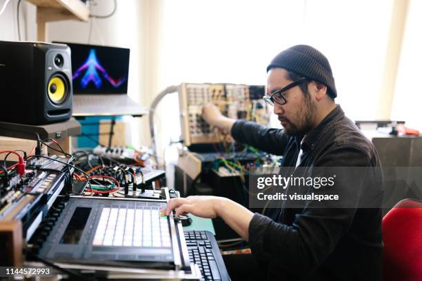 asian man producing electronic music - edm dj stock pictures, royalty-free photos & images