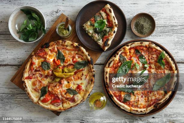 carbonara pizza and meat pizza - rustic plate overhead stock pictures, royalty-free photos & images