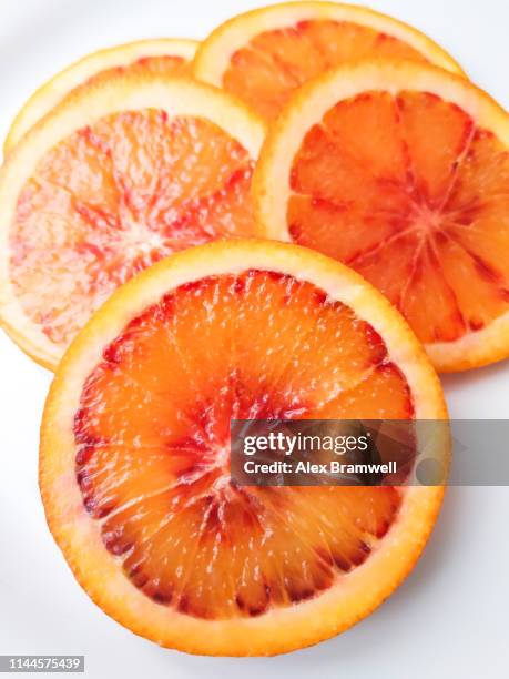 spanish blood orange slices - bloedsinaasappel stockfoto's en -beelden