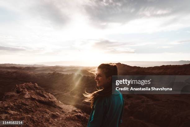 woman feeling freedom and happiness meeting sunset at moon valley in chile - atacama stock pictures, royalty-free photos & images