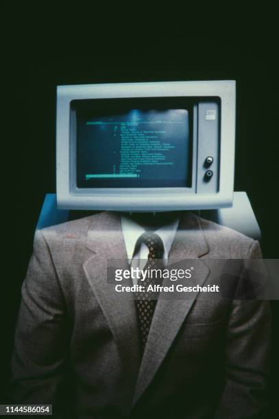 An IBM computer with a green monochrome monitor superimposed on a man wearing a suit, US, 1983.