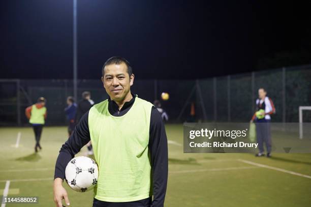 middle aged man holding a soccer ball - pettorina foto e immagini stock