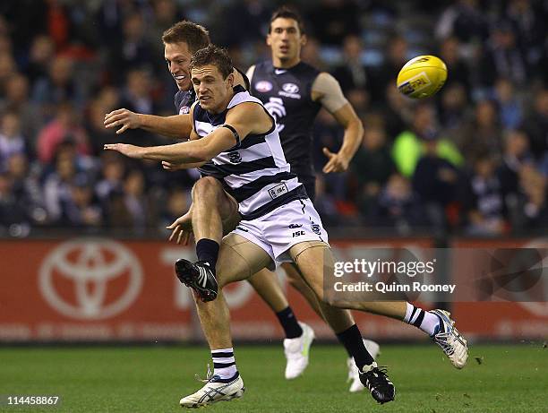 Joel Selwood of the Cats attempts to smouther a kick by Bret Thornton of the Blues during the round nine AFL match between the Carlton Blues and the...
