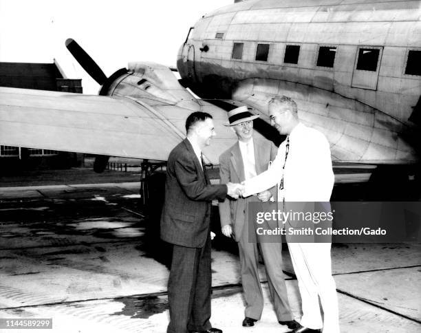 Full length portrait of Hugh Latimer Dryden and John F Victory welcomed by engineer Henry Reid at the Langley Memorial Aeronautical Laboratory in...