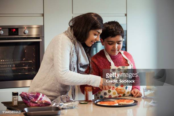 making pizza is fun - asian family cooking stock pictures, royalty-free photos & images