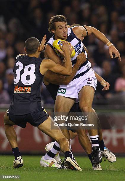 Corey Enright of the Cats is tackled by Jeff Garlett and Eddie Betts of the Blues during the round nine AFL match between the Carlton Blues and the...