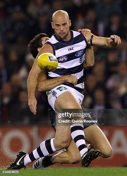 Paul Chapman of the Cats kicks whilst being tackled by Kade Simpson of the Blues during the round nine AFL match between the Carlton Blues and the...