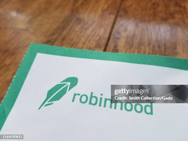 Close-up of logo for investment management app Robinhood on paper, against a light wooden surface, April 21, 2019.